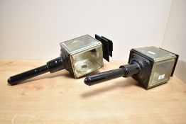 A pair of black painted metal and glass carriage lamps having pagoda type surmounts and marked to
