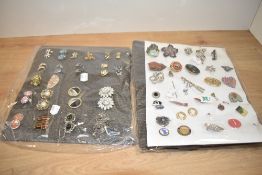 An assortment of costume brooches and earrings, including paste set examples, enamel pieces and