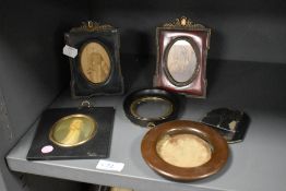 A 19th century miniature portrait of a gentleman mounted behind a gilt oval surround borded within a
