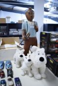 A wooden model of Tin Tin with dog and two soft toy dogs
