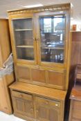 An Ercol golden dawn bookcase with cocktail section over double drawer and cupboard base, dimensions