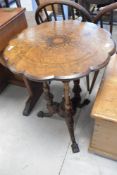 A 19th Century walnut occasional table having shaped inlaid top on triple column supports