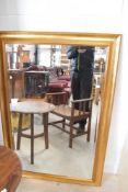A large gilt effect wall mirror, approx. 126 x 85cm