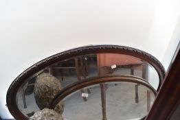 Two vintage oval wall mirrors, oak and mahogany