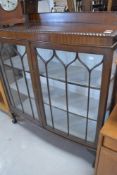 A late 19th or early 20th Century mahogany display cabinet, have gadrooned edge and ledge back,