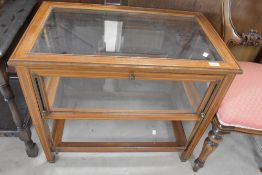 A late Victorian or Edwardian mahogany bijoutuerie table having inlaid decoration and lift sides,