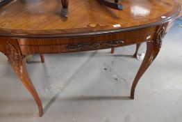 A continental style oval dining table, having quarter veneer and inlay style top, with applique