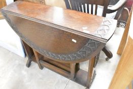 An Arts & Crafts oak gateleg table having carved decoration, width approx.92cm