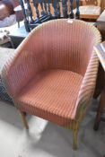A vintage Lloyd Loom tub chair in pink on gold
