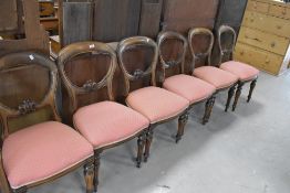 A set of six Victorian mahogany balloon back dining chairs with later upholstery to overstuffed