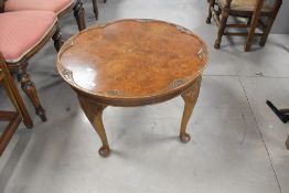 An early to mid 20th Century walnut coffee table having raised carved edge, diameter approx. 65cm