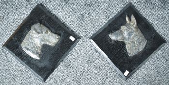 A pair of Continental cast silver-plate dog head plaques, mounted to black stained and chamfered oak