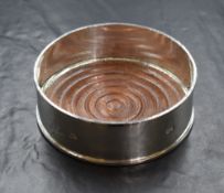 An Elizabeth II silver wine coaster, of traditional form with moulded rim and base, having wooden