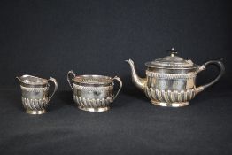 A Victorian silver three piece tea set, comprising a tea pot, sugar and cream, of oval form having a