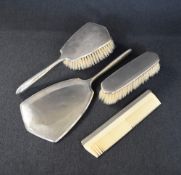 A late George VI silver mounted vanity set, comprising a hair brush, clothes brush, mirror and comb,