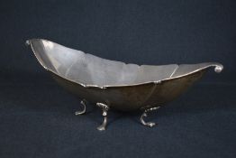 An impressive George V silver bowl, of boat form having a lobed rim, canted sides and scroll