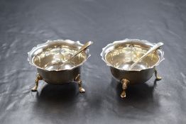 A pair of Edwardian silver salts, having Chippendale style rims raised on three cabriole style legs,