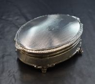 An Elizabeth II silver trinket box, of oval form having an egg and dart rim with scroll ends and