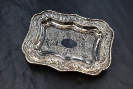 A Chinese white metal pin tray, having a bamboo motif rim, embossed dragons with clouds and pearls