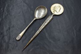 A cased Elizabeth II silver Silver Jubilee letter opener, the Silver Jubilee commemorative coin on a