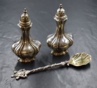 A pair of Edwardian silver pepperettes, of bulbous form having decorative moulding to body, marks