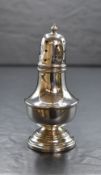 A George V silver pepperette, of bulbous form having finial top with moulded decoration, raised on a