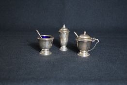 A cased George V silver condiment set, comprising salt, mustard and pepper with spoons, of