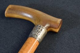 A Victorian silver mounted walking stick, the wooden cane with curved horn handle, having decorative