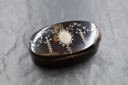 A 20th century white metal inlaid tortoiseshell trinket box, of hinged oval form having a vacant