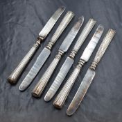 A cased set of six Edwardian silver handled knives, having decorative step work to the handles,