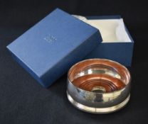 An Elizabeth II silver wine coaster, of traditional form with moulded rim and base, having wooden