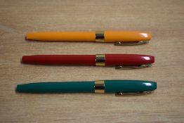 Three Sheaffer Imperial Rollerball pens in Orange, Red, and Green