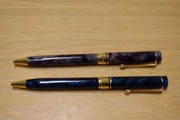 Two L'Plume ballpoint pens one blue the purple with gold trim