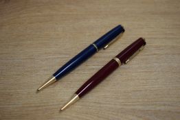 Two Parker Duofold propelling pencils one red with broad cap band one blue with narrow cap band