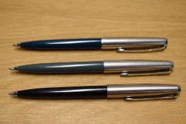 Three Parker 45 ballpoint pens in grey, teal and black