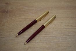 Two Parker 45 ballpoint pens in red with rolled gold cap. Slight dent to one cap