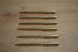 Six Parker 61 ballpoint pens in fluted gold (one engraved)
