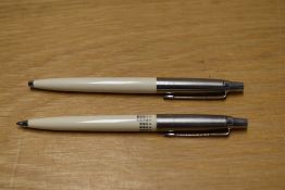 Two Parker Jotter ballpoint pens in ivory (one with a calendar print)