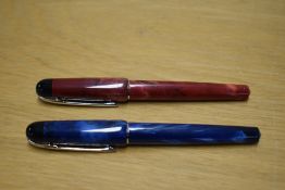 Two Waterman Phileas rollerball pens in Red Laque and Blue Laque with chrome trim, some