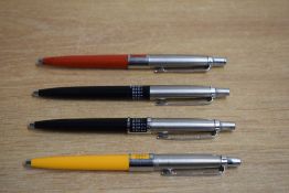 Four Parker Jotter ballpoint pens with perpetual calendars. In yellow, red and two black. one
