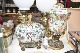 A ceramic oriental style lidded cachepot, decorated with floral patterns and raised on a ormolou