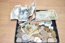 A box containing various bank notes and coins, to include a $1 Tonga bank note, a 2 Francs coin