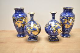 A pair of blue and gold vases of baluster form, decorated with Chinese figures within a