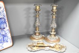 A pair of white metal candlesticks decorated with acanthus leaf raised on circular feet, h26cm, sold