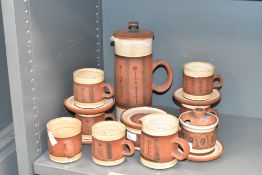 A G. Fox studio pottery tea service decorated with floral patterns on a burnt red ground, makers