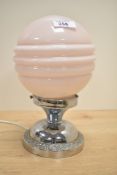 An Art Deco style table lamp having pink glass shade supported on a chrome circular base, h24cm A/F