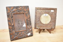 A carved oak Arts and Crafts style photograph frame decorated with floral and foliage patterns,