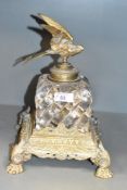 A Victorian cast brass and glass ink well, mounted on an exuberant base having paw feet and stylised