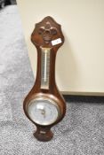 An early 20th century oak barometer having temperature gauge and carved floral patterns, h60cm