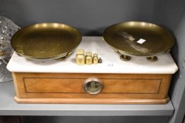 A 20th century Boulangerie balance scale having white marble top and brass weights, L47cm